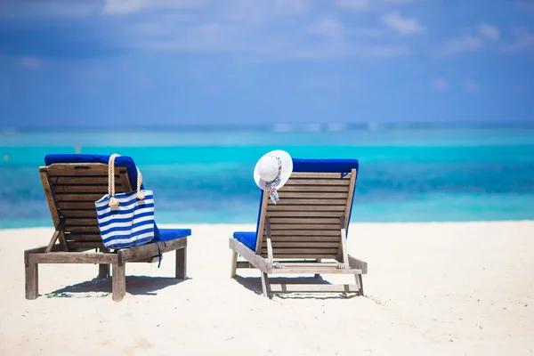 White hat and bag on lounge chairs at tropical sandy beach — Stock Photo, Image