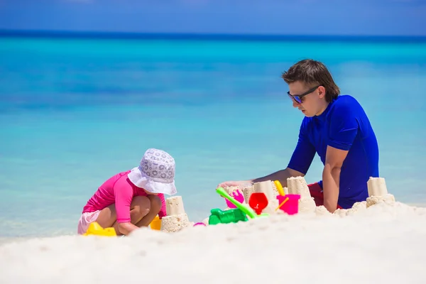Holčička a otec hraje s hračkami, pláž na letní dovolenou — Stock fotografie