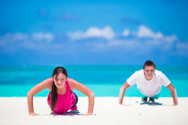 熱帯のビーチの屋外クロス トレーニングのワークアウト中に腕立て伏せをやって若いフィットネス カップル — ストック写真