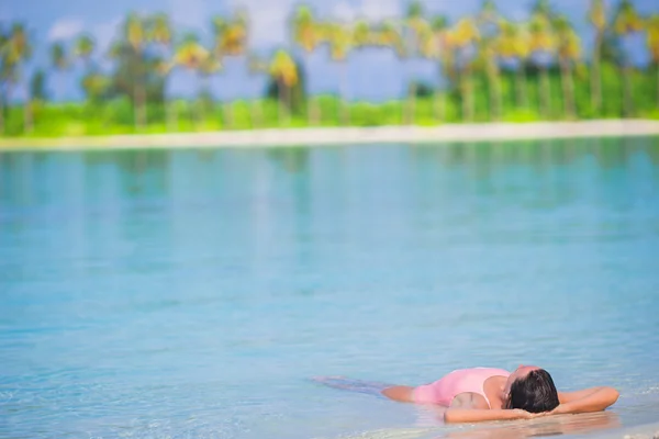 Jonge gelukkig vrouw ontspannen op witte zandstrand — Stockfoto