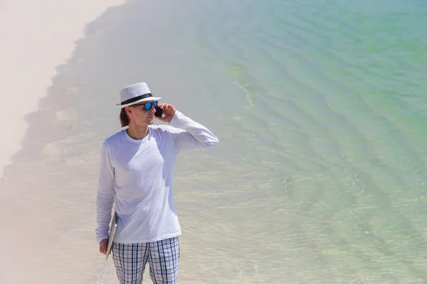 Unga företag man ringer genom mobilen på vita stranden — Stockfoto