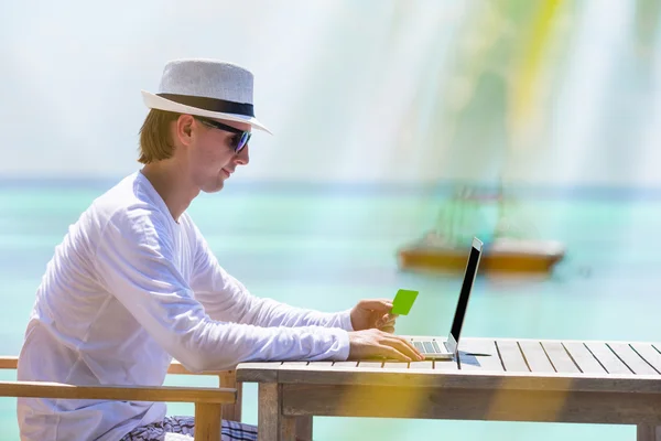 Giovane con tablet computer sulla spiaggia tropicale — Foto Stock