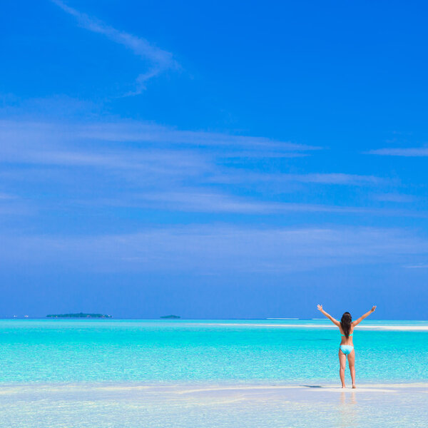 Young happy woman on white sandy beach