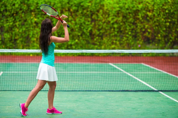 Junge aktive Frau spielt im Tropenurlaub Tennis — Stockfoto