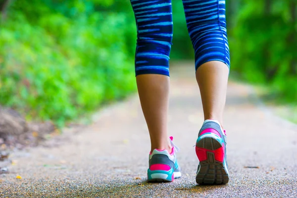 Крупним планом на взутті спортсмена бігун жіночі ноги біжать по дорозі — стокове фото