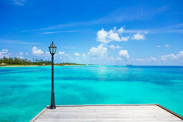 Lantern on the bridge at wooden pier with turquoise water at ideal island — Stock Photo, Image