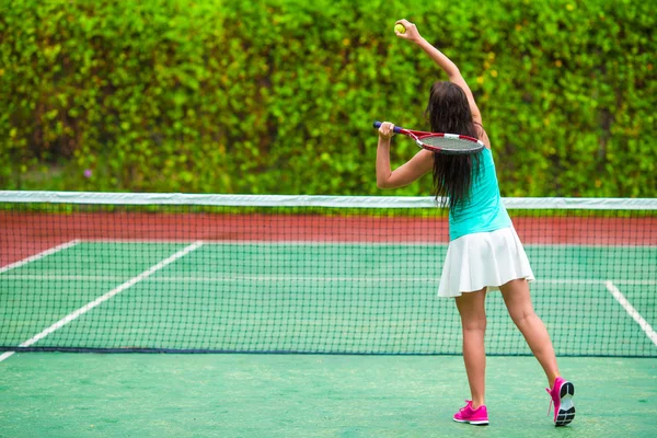 Jovem mulher ativa jogando tênis em férias tropicais — Fotografia de Stock