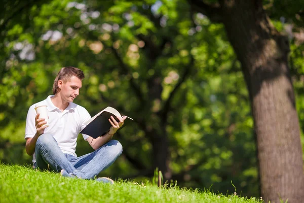 Kluger Mann im Park draußen schreibt seine Gedanken in ein Notizbuch — Stockfoto