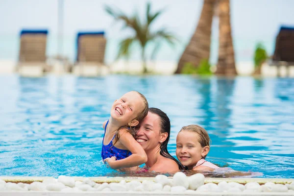 妈妈和两个孩子在豪华游泳池里享受暑假 — 图库照片