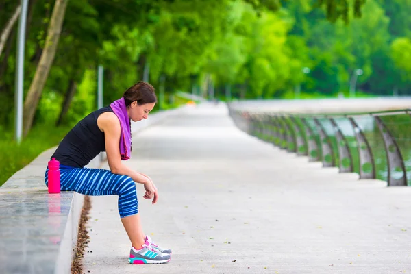 Mladý aktivní fitness žena s mat a láhev vody venku — Stock fotografie