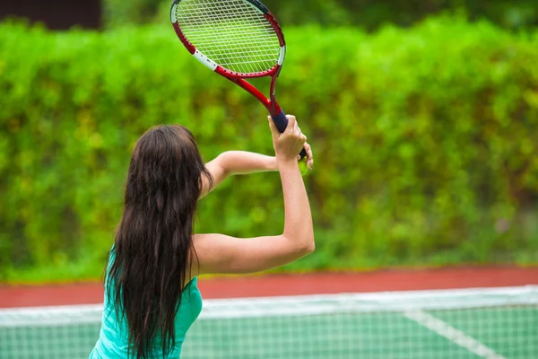 Junge aktive Frau spielt im Tropenurlaub Tennis — Stockfoto