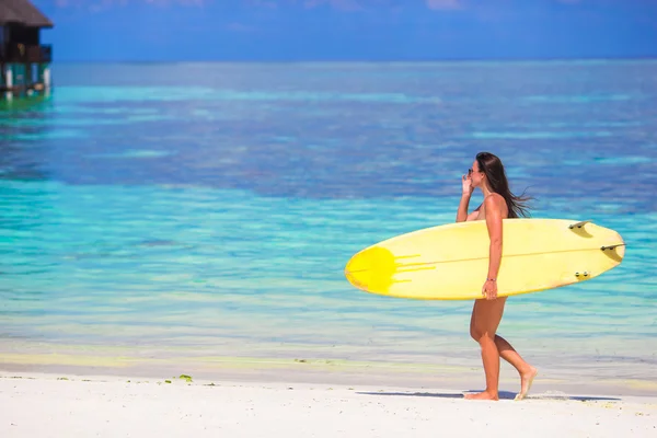 Happy shapely surf woman at white beach with yellow surfboard — Stock Photo, Image