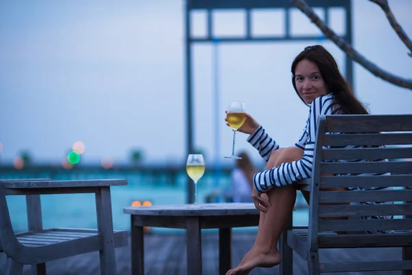 Tânără fată cu vin alb la cafenea în aer liber seara — Fotografie, imagine de stoc