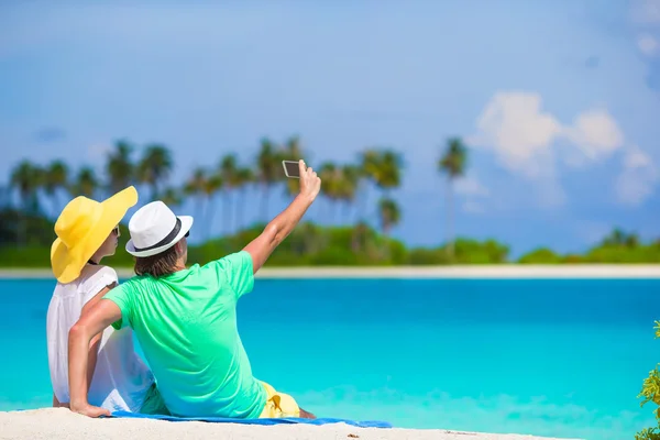 Família de dois fazendo uma selfie com celular na praia — Fotografia de Stock