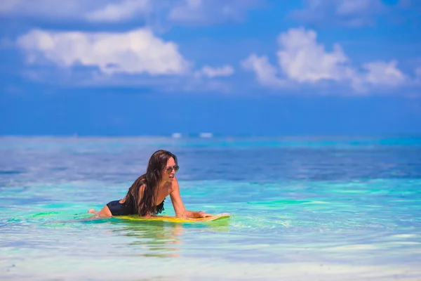 Young slender surf girl at white beach with yellow surfboard — Stock Photo, Image
