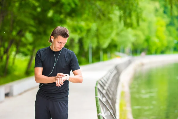 Runner guardando smart watch cardiofrequenzimetro avendo pausa durante la corsa — Foto Stock