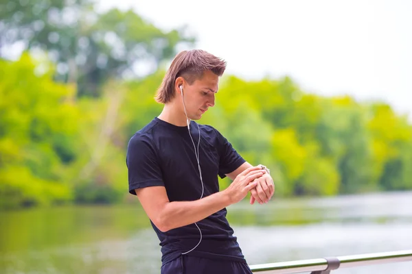 Runner guardando smart watch cardiofrequenzimetro avendo pausa durante la corsa — Foto Stock