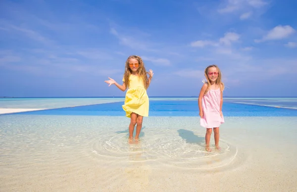 Красивые маленькие девочки играют в открытом бассейне — стоковое фото