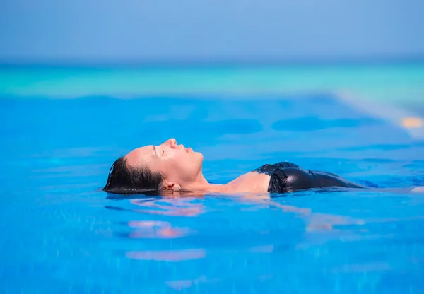 水と屋外のスイミング プールで日光浴を楽しむ若い女性. — ストック写真