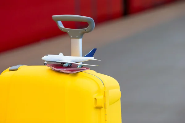 Rode paspoorten en vliegtuig kleine model op gele bagage bij treinstation — Stockfoto