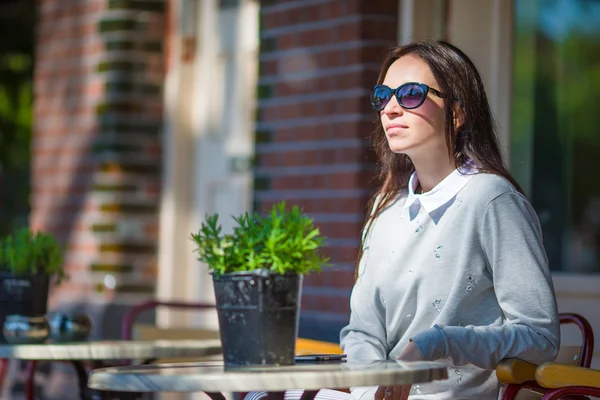 Krásná žena, sedí v kavárně venku na Evropské město — Stock fotografie