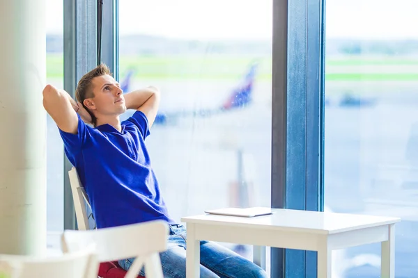 Joven hombre caucásico en el aeropuerto esperando el embarque — Foto de Stock