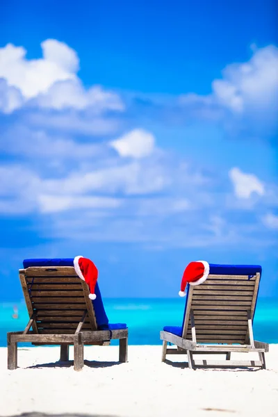 圣诞节热带概念: 沙滩躺椅与红色的圣诞帽 — 图库照片
