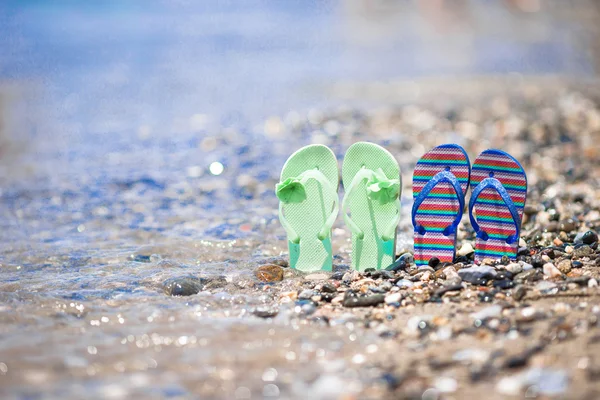 Kids flip flops on beach in front of the sea — Stock Photo, Image