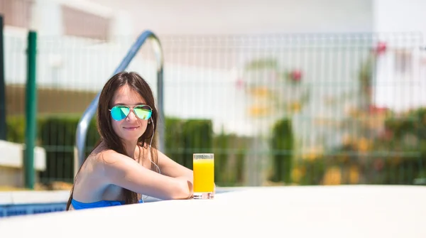 Junge schöne Frau hört Musik mit Kopfhörern in der Nähe von Schwimmbad — Stockfoto