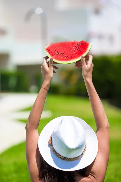 Primer plano chica en sombrero y gafas de sol con sandía relajante cerca de la piscina — Foto de Stock