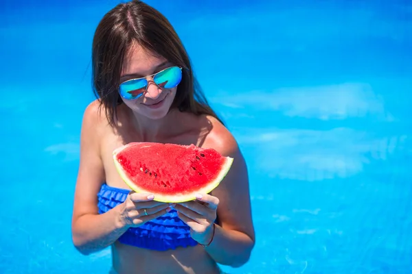 Jeune fille heureuse en lunettes de soleil avec pastèque relaxant dans la piscine — Photo