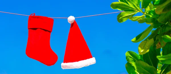 Concetto di Natale: cappello di Babbo Natale e calza sfondo cielo blu — Foto Stock