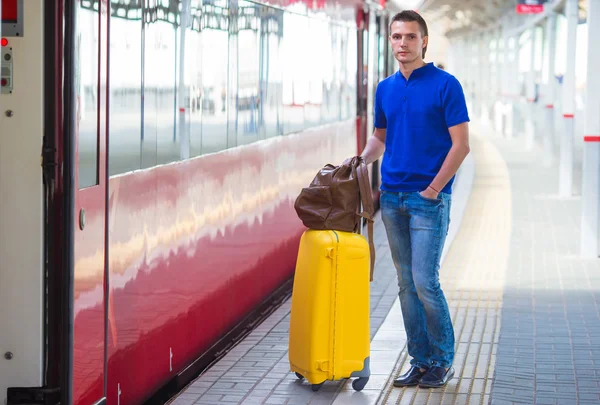 Young man with baggage at a train station — Stock Photo, Image