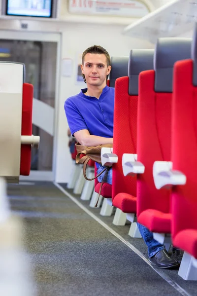 Junger glücklicher Mann mit dem Zug unterwegs — Stockfoto