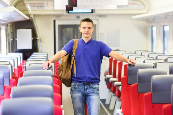 Junger glücklicher Mann mit dem Zug unterwegs — Stockfoto