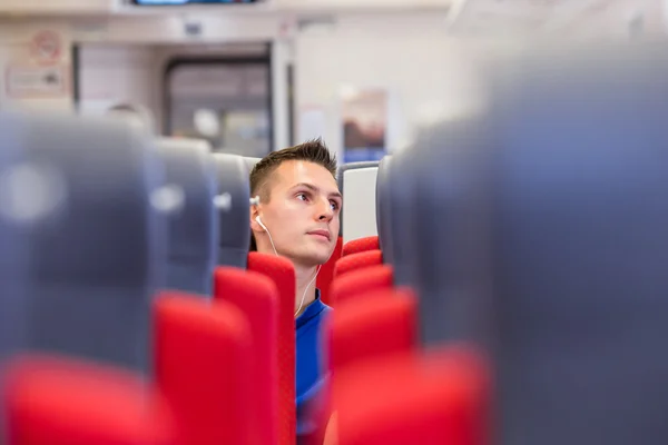 Junger glücklicher Mann mit dem Zug unterwegs — Stockfoto