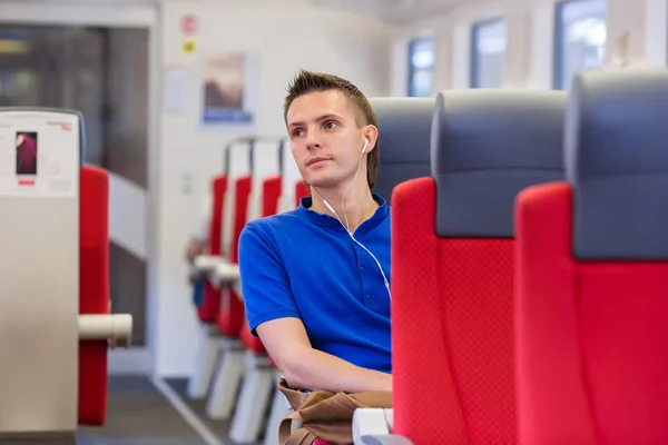 Junger glücklicher Mann mit dem Zug unterwegs — Stockfoto