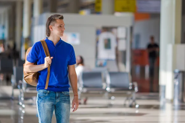 Młody człowiek kaukaski na lotnisko kryty czekając na wejście na pokład — Zdjęcie stockowe