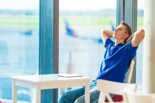 白种人年轻人在机场室内等待登机 — 图库照片