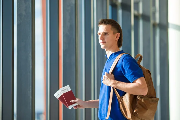 Jonge man bedrijf paspoort en instapkaart op luchthaven — Stockfoto