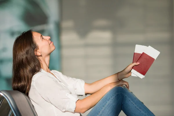 Joyeux jeune femme avec billet d'avion et passeports à l'aéroport en attente de vol — Photo