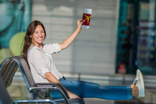 Mujer feliz con pequeño modelo de avión y pasaportes en el aeropuerto —  Fotos de Stock