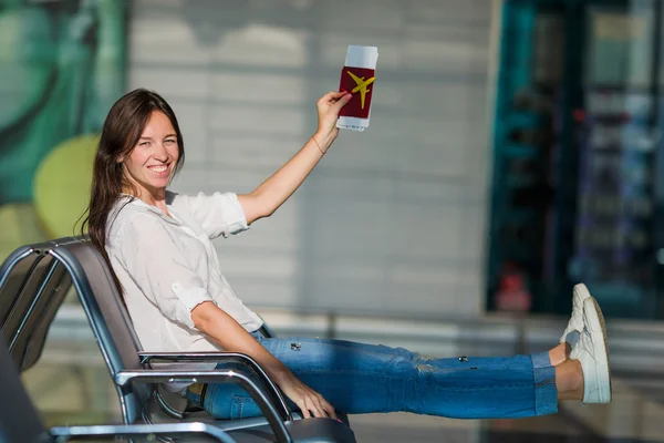 Happy woman with small model airplane and passports in airport — Stock Photo, Image