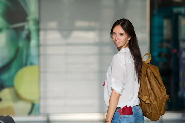 Gelukkig jonge vrouw met vliegticket en paspoorten op luchthaven wachten voor instappen — Stockfoto