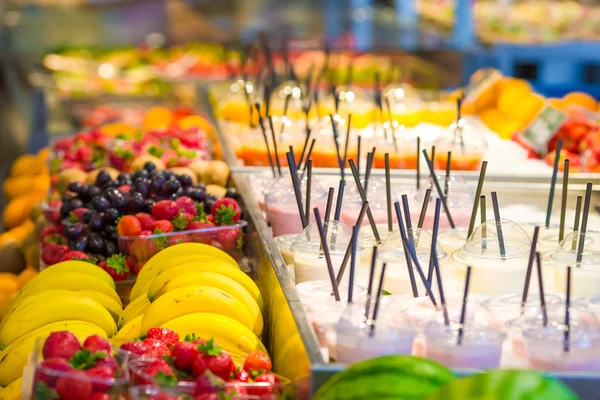 Deliciosos cócteles dulces y frutas frescas en la tienda con comida para llevar —  Fotos de Stock