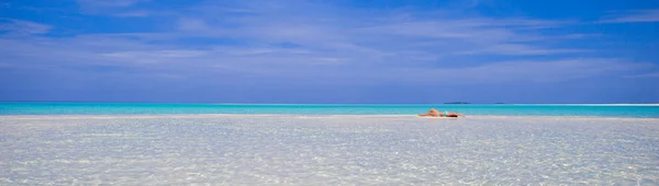 Jonge mooie vrouw aan ondiep tropisch water — Stockfoto