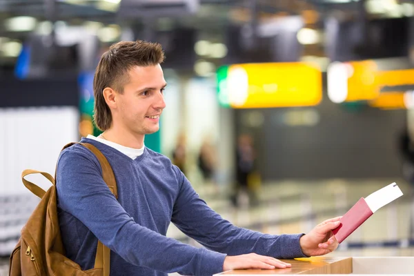 Mooie man met paspoorten en boarding passeert bij de receptie in airport — Stockfoto