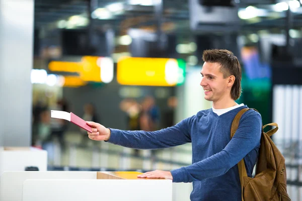 Belo homem com passaportes e cartões de embarque na recepção do aeroporto — Fotografia de Stock