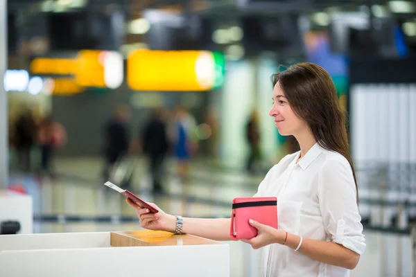 Mulher bonita com passaportes e cartões de embarque na recepção do aeroporto — Fotografia de Stock