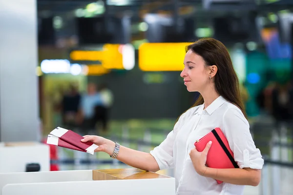 Young girl with passports and boarding passes at the front desk at international airport — Stock Photo, Image